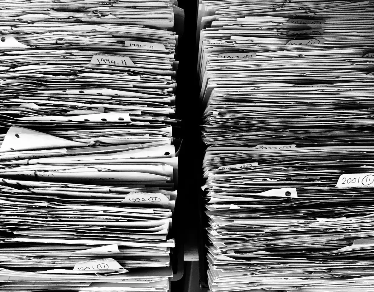 Hands of an adult filling out a school support plan form on a desk with documents and a pen